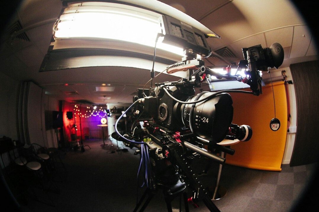 Wide shot of a large modern broadcast studio floor with cameras and lighting