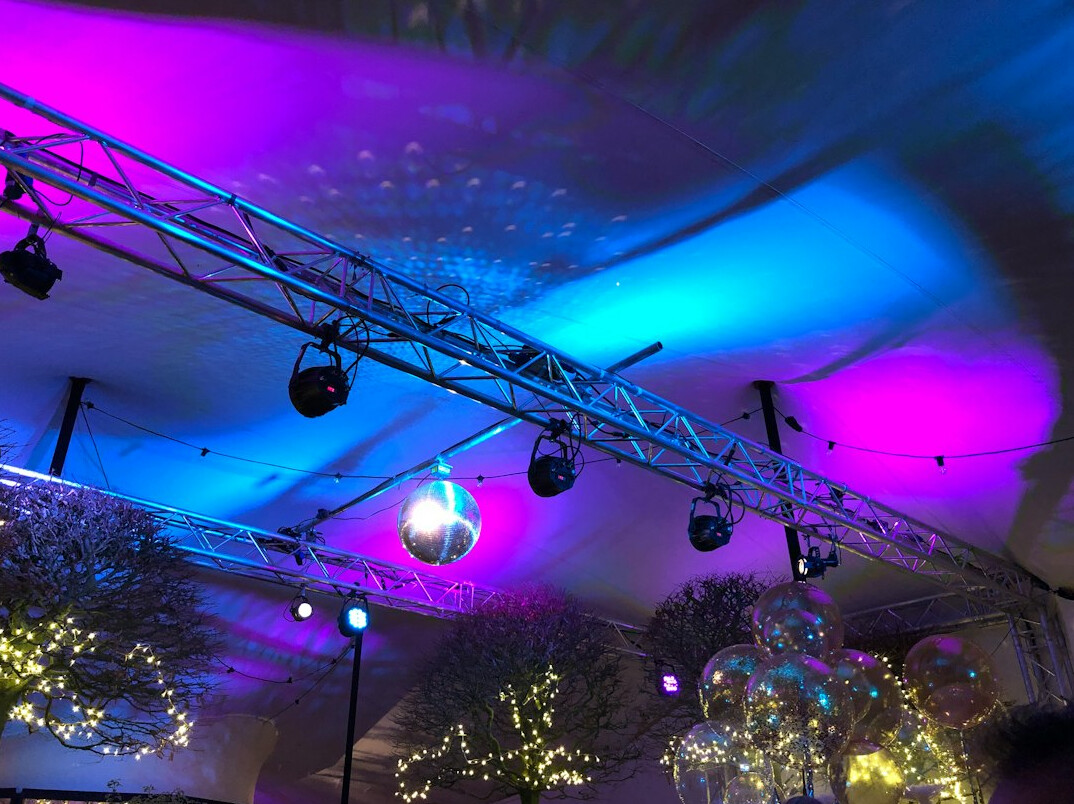 Stage lighting rig with moving head fixtures and coloured beams