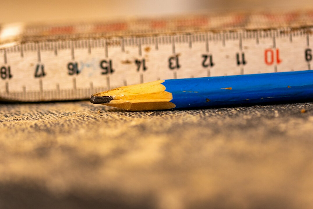 Architectural floor plan of a television studio on a desk with a scale ruler